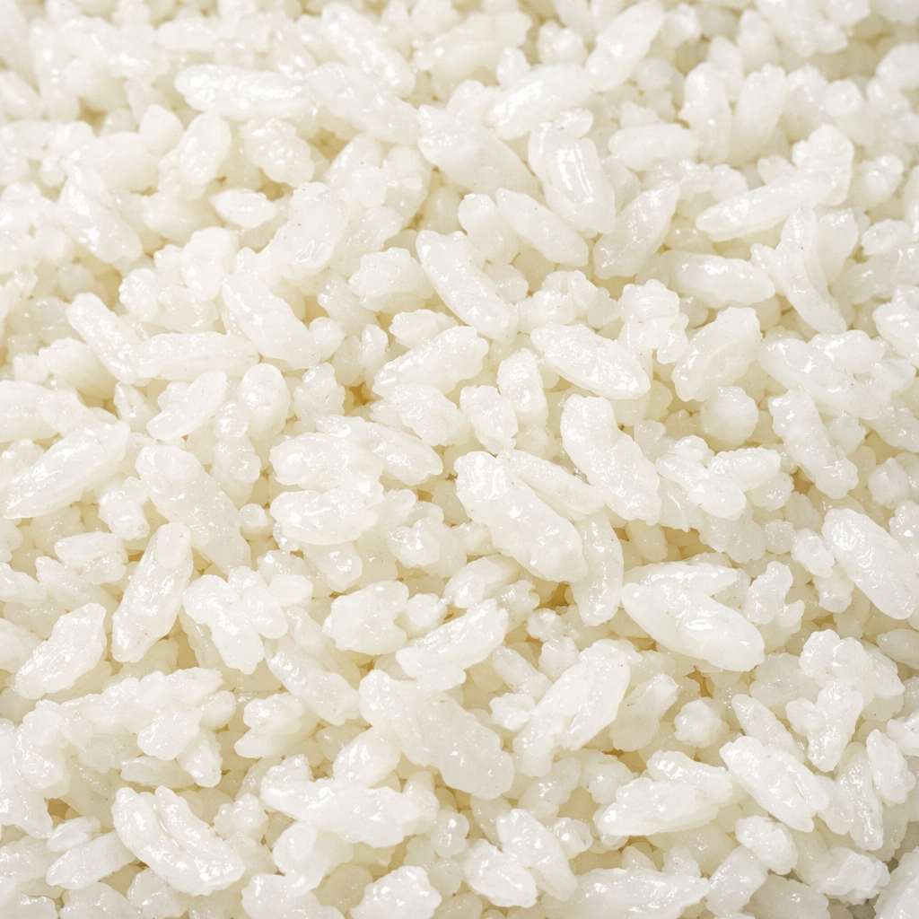 Cooked white rice grains closely packed together with a soft, slightly shiny texture